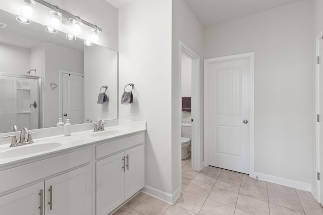 bathroom featuring tile patterned flooring, vanity, an enclosed shower, and toilet