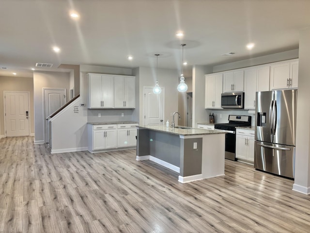 kitchen featuring white cabinetry, pendant lighting, an island with sink, and appliances with stainless steel finishes