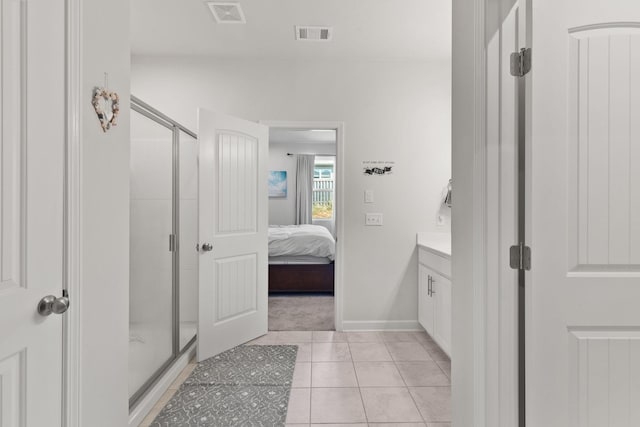 bathroom with tile patterned flooring, vanity, and walk in shower