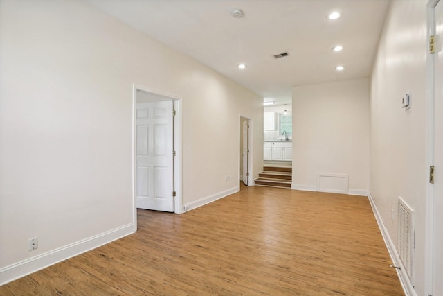 empty room featuring sink and light hardwood / wood-style flooring