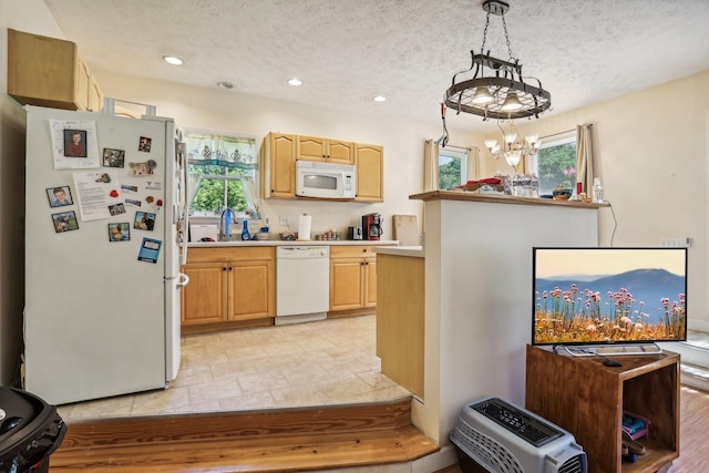 kitchen featuring an inviting chandelier, heating unit, pendant lighting, white appliances, and light brown cabinetry