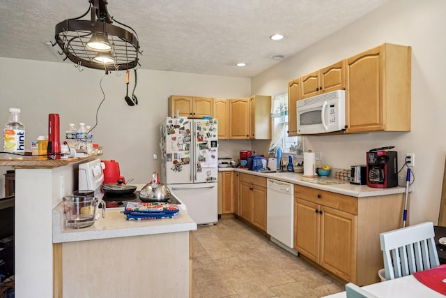 kitchen with pendant lighting, white appliances, a textured ceiling, and light brown cabinetry