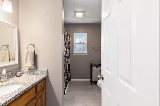 bathroom with tile patterned floors, vanity, and toilet