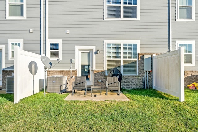 rear view of house with central AC, a yard, and a patio