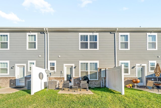 back of property with central AC, a yard, and a patio