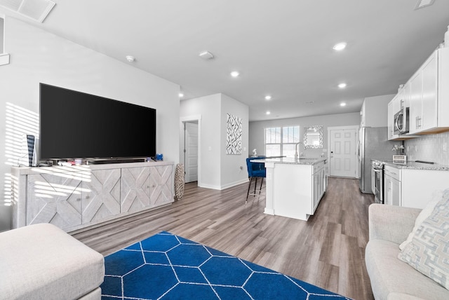 living room with sink and light hardwood / wood-style floors