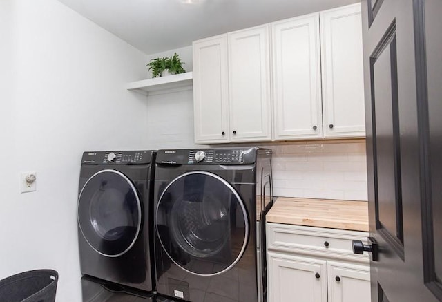 washroom featuring tile patterned floors, washing machine and dryer, and cabinets