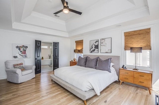 bedroom with a raised ceiling, ceiling fan, crown molding, and light hardwood / wood-style floors