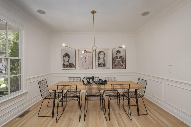 dining space with a chandelier, ornamental molding, a wealth of natural light, and light hardwood / wood-style flooring