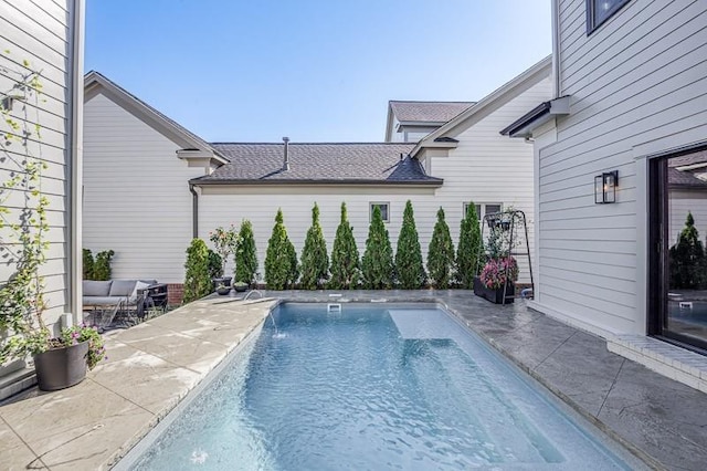 view of pool with pool water feature and a patio