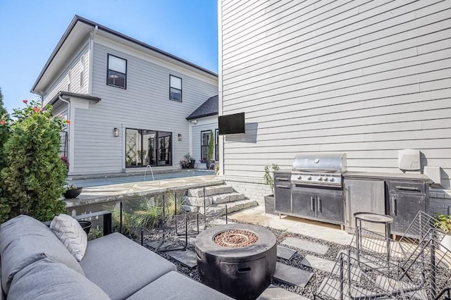 rear view of property featuring a patio, area for grilling, and an outdoor living space with a fire pit