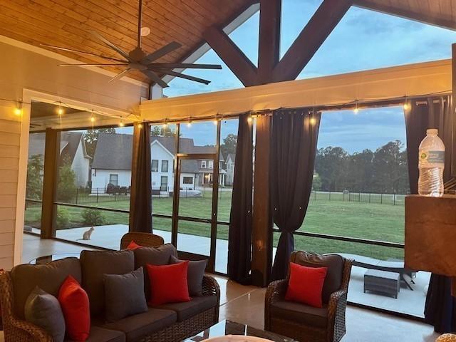 sunroom with ceiling fan, lofted ceiling, and wooden ceiling