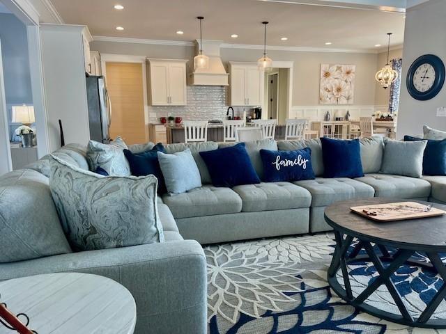 living room featuring a chandelier and crown molding