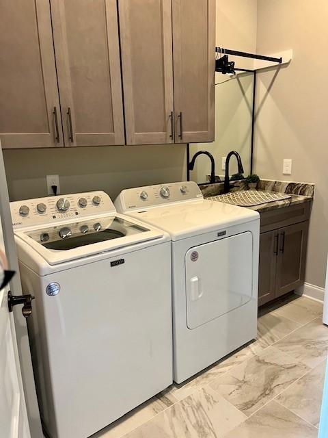 washroom featuring cabinets, sink, and washing machine and clothes dryer