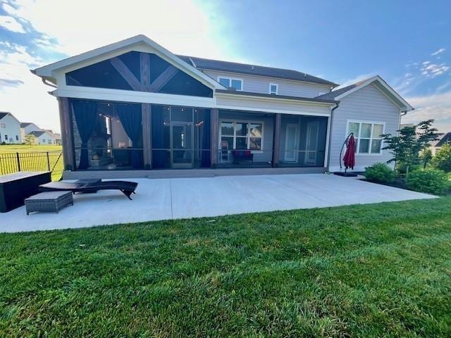 rear view of house with a sunroom and a lawn