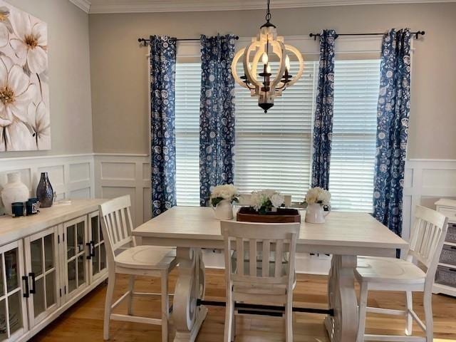 dining space featuring a notable chandelier, wood-type flooring, and crown molding