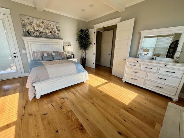 bedroom featuring light hardwood / wood-style flooring, beamed ceiling, and ornamental molding