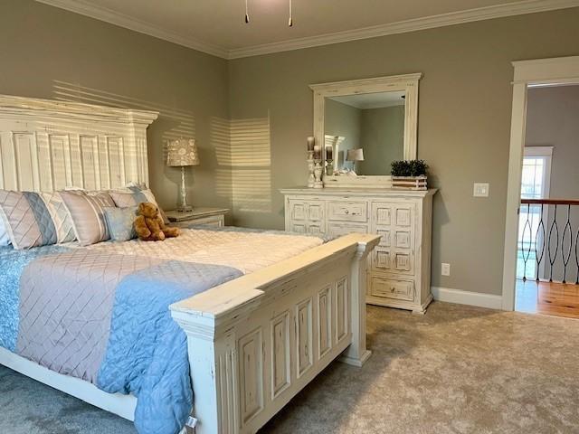 bedroom featuring light colored carpet and ornamental molding