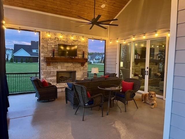 view of patio / terrace featuring an outdoor stone fireplace and ceiling fan