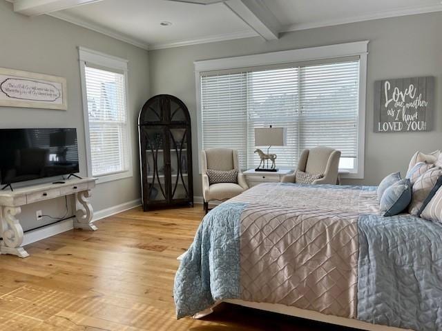 bedroom with beam ceiling, multiple windows, and hardwood / wood-style flooring