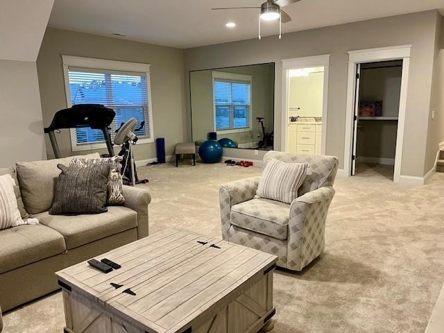 living room featuring light colored carpet and ceiling fan