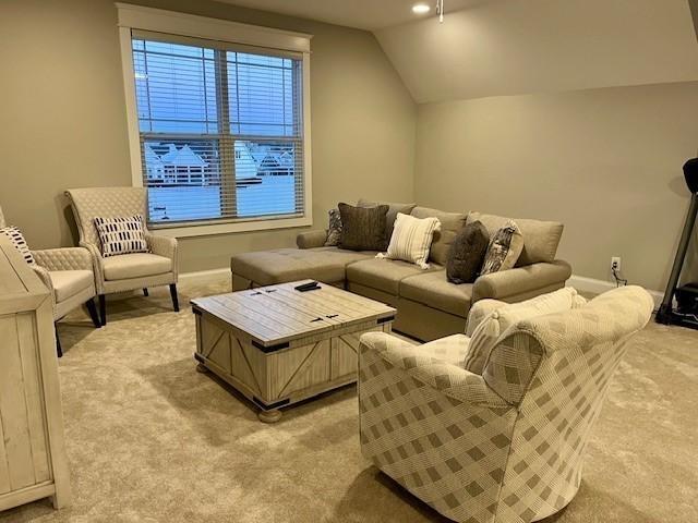 carpeted living room featuring vaulted ceiling