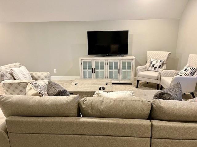 carpeted living room with lofted ceiling