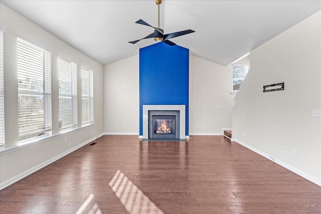 unfurnished living room with ceiling fan, dark wood-type flooring, and vaulted ceiling