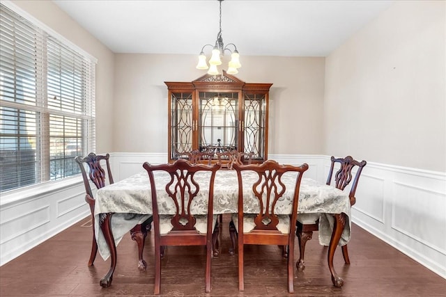 dining space with dark hardwood / wood-style flooring and an inviting chandelier