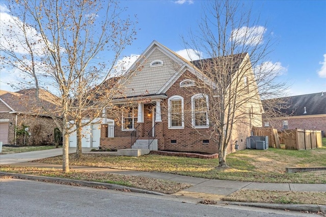 view of front of property featuring central AC unit, a garage, and a front yard