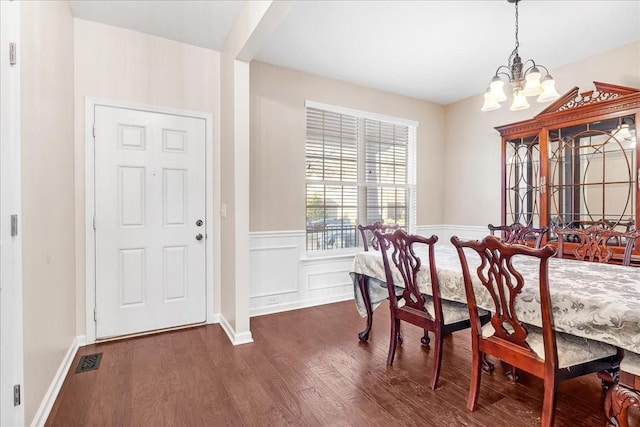 dining area featuring dark hardwood / wood-style flooring and an inviting chandelier