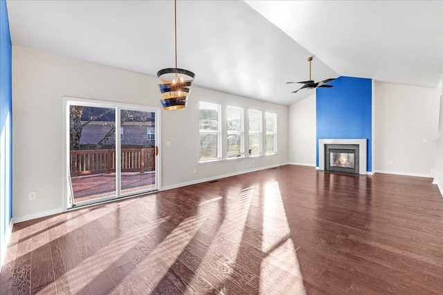 unfurnished living room featuring hardwood / wood-style floors, ceiling fan with notable chandelier, and vaulted ceiling