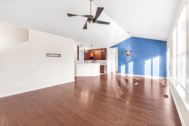 unfurnished living room with vaulted ceiling, ceiling fan, and dark wood-type flooring