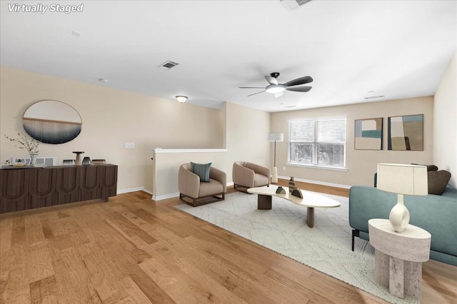 living room featuring ceiling fan and light hardwood / wood-style flooring