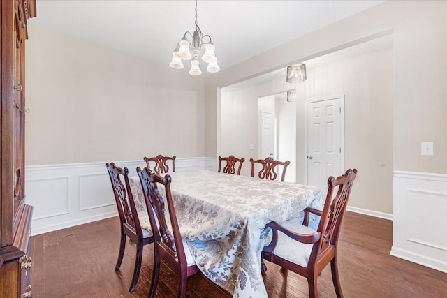 dining room featuring dark hardwood / wood-style flooring and an inviting chandelier