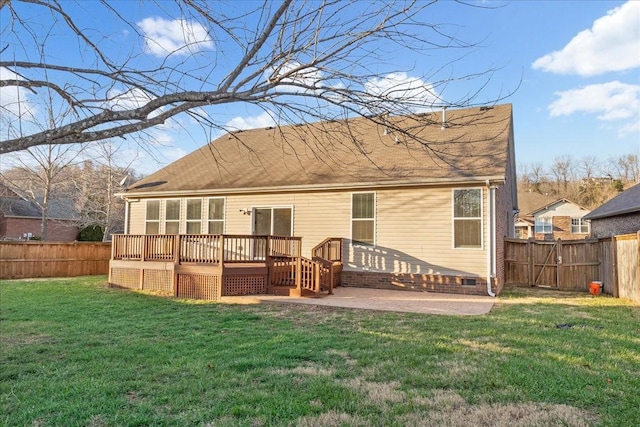 back of house featuring a deck, a patio area, and a lawn