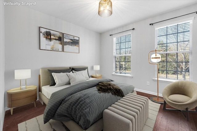 bedroom with dark hardwood / wood-style flooring and multiple windows