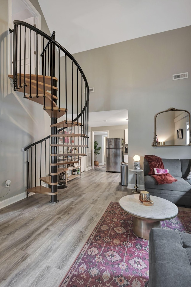 interior space with a high ceiling and hardwood / wood-style flooring