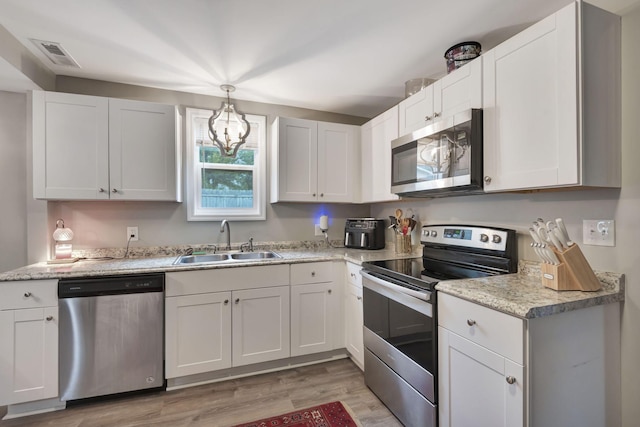 kitchen featuring white cabinets, stainless steel appliances, light hardwood / wood-style flooring, and sink