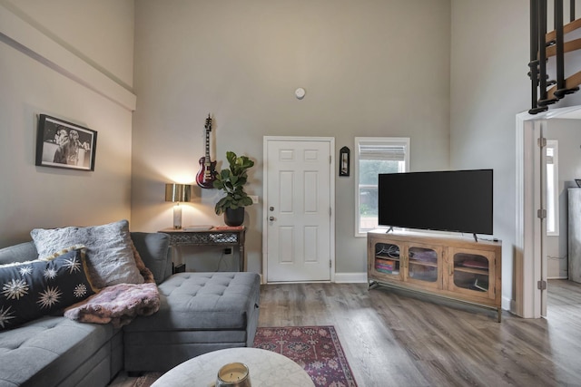 living room featuring light hardwood / wood-style flooring and a high ceiling