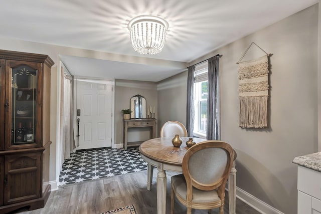 dining space with wood-type flooring and an inviting chandelier