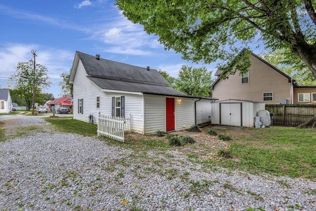 back of house featuring a storage unit