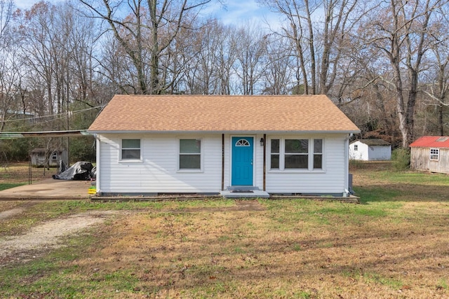 view of front of property with an outbuilding and a front lawn