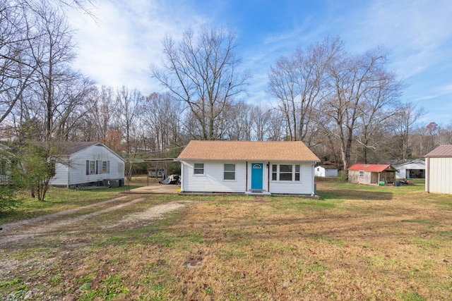 ranch-style house featuring a front yard, an outbuilding, and a carport