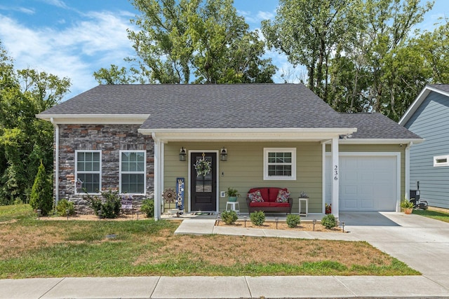 view of front facade with a front yard, a porch, and a garage