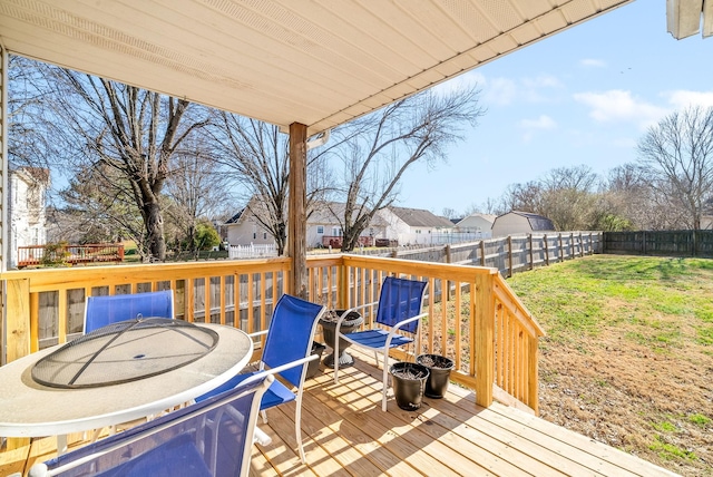 wooden terrace featuring a lawn