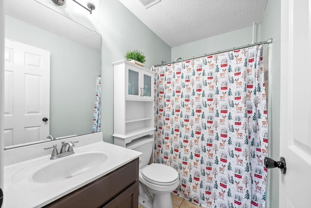 bathroom featuring vanity, tile patterned floors, toilet, a textured ceiling, and walk in shower