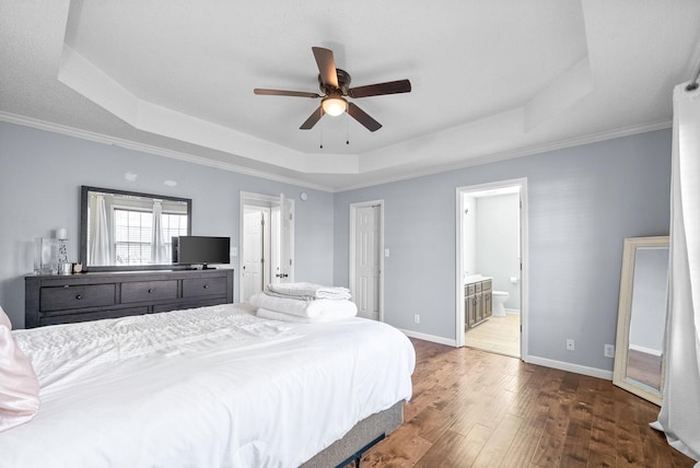 bedroom featuring ensuite bathroom, ceiling fan, a raised ceiling, and dark hardwood / wood-style floors