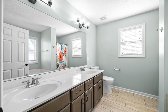 full bathroom with vanity, independent shower and bath, a textured ceiling, and toilet