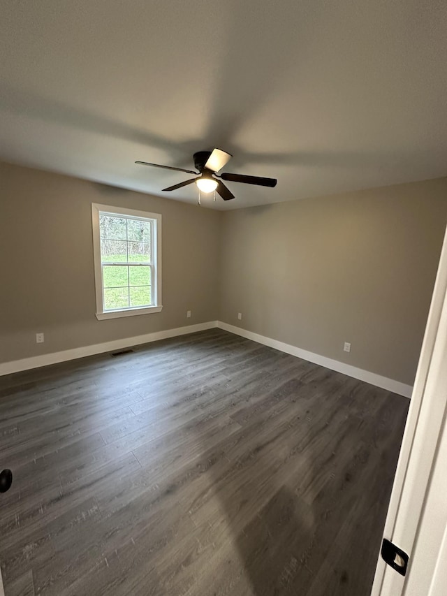 spare room featuring ceiling fan and dark wood-type flooring